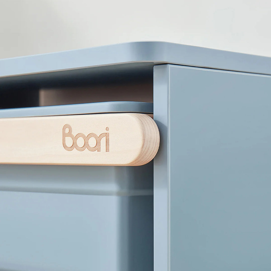 Close-up of a blue cabinet with a wooden handle featuring the 'boori' brand.