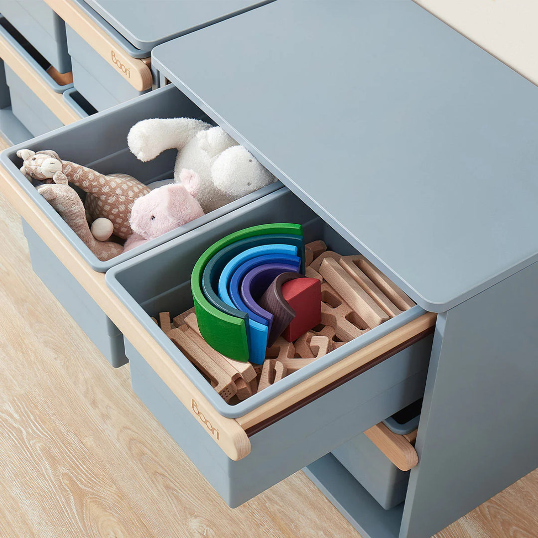 Children's toy storage unit with toys inside on a wooden floor