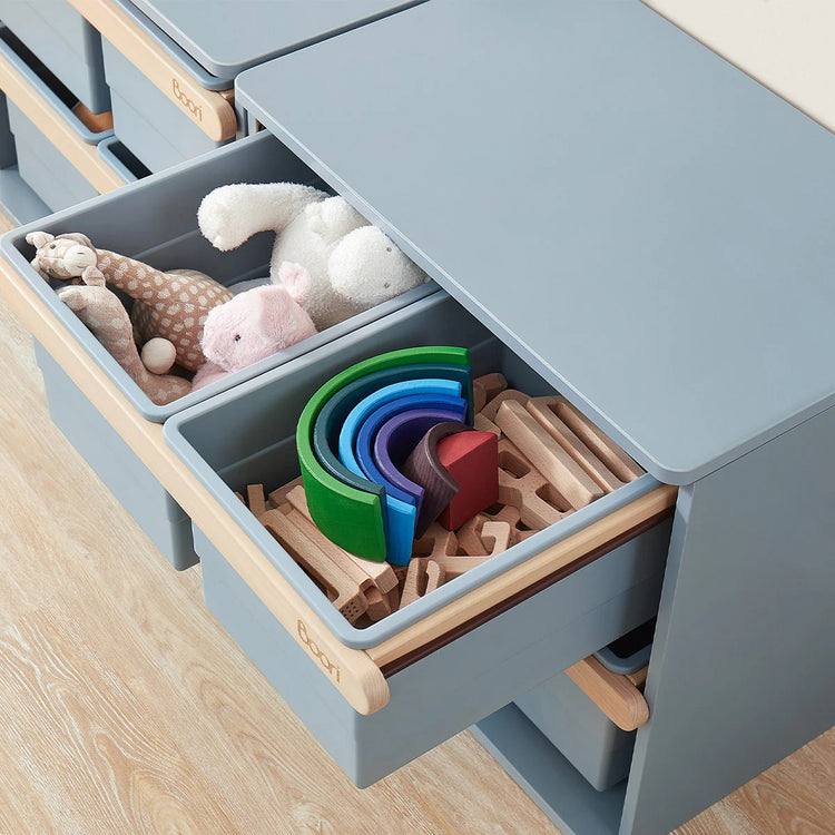 Children's toy storage unit with toys inside on a wooden floor