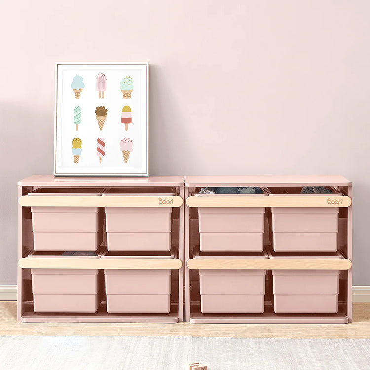 Wooden storage unit with pink bins and a framed picture of ice cream cones on a light pink wall.