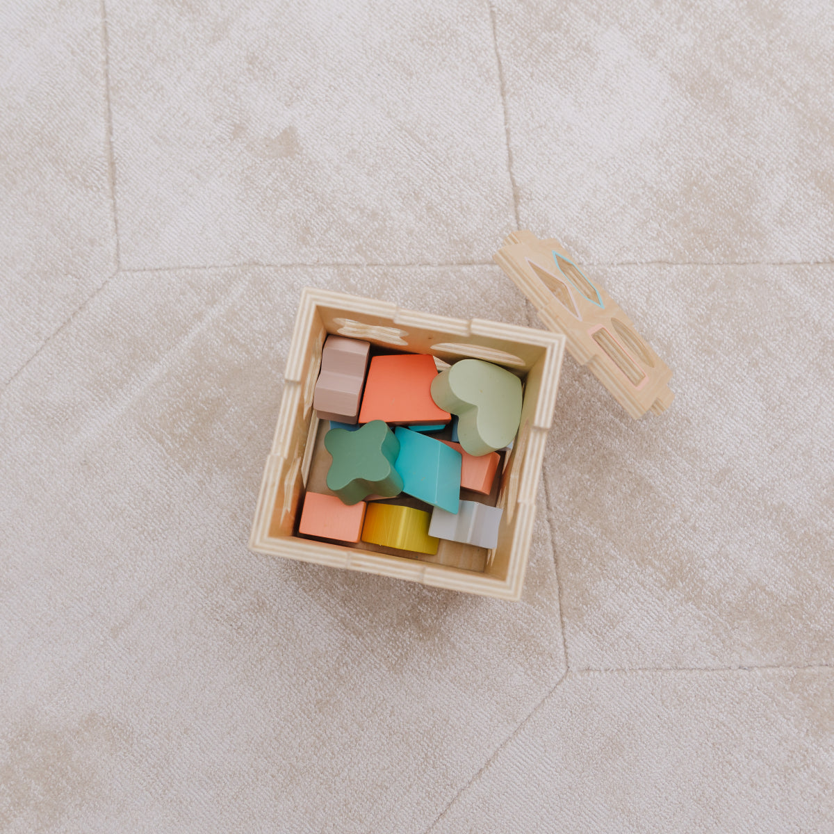 Colorful wooden blocks in a box on a light-colored floor