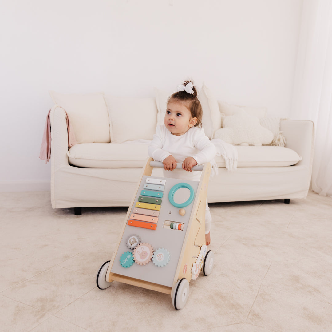 Child playing with a toy activity center in a living room.