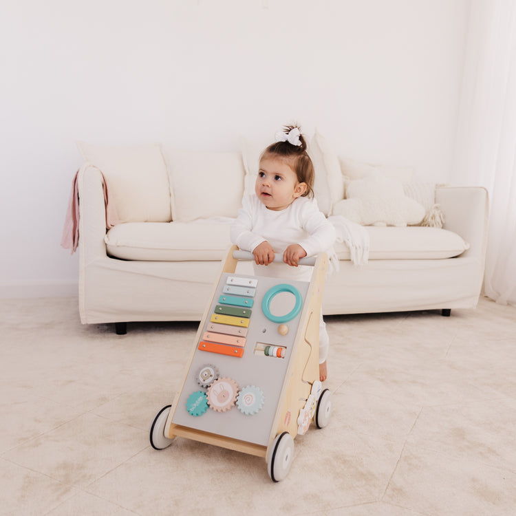 Child playing with a toy activity center in a living room.