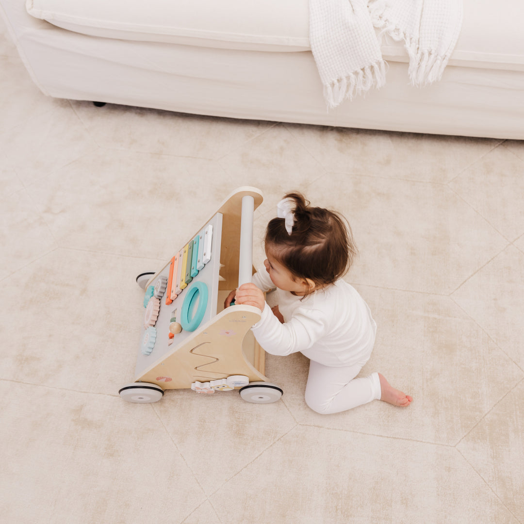 Child playing with a wooden toy on a carpeted floor