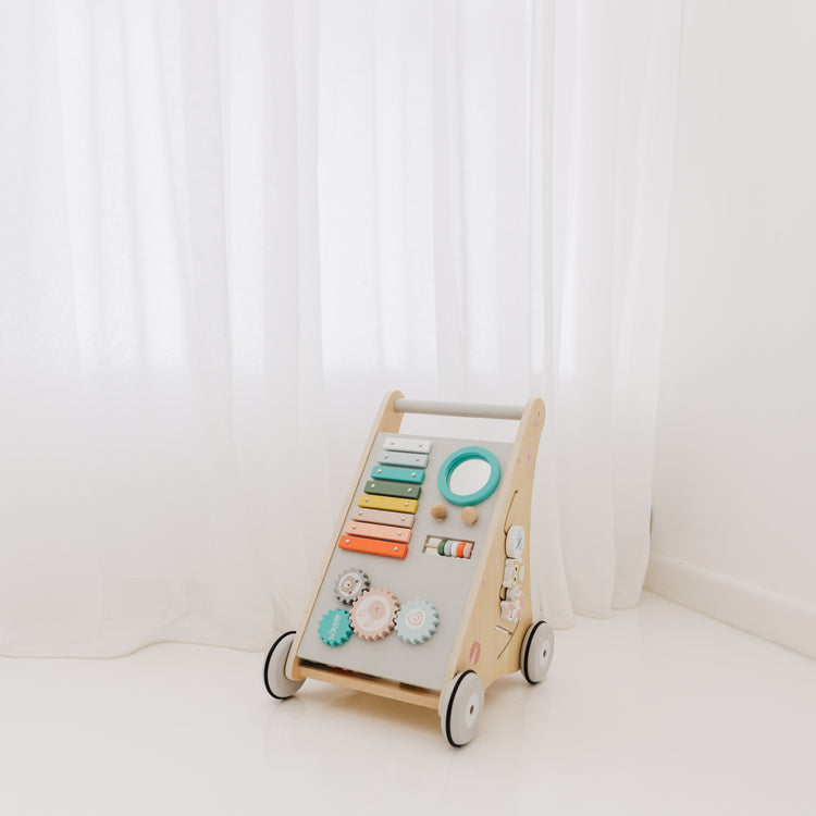 Wooden children's activity walker with colorful knobs on a white background