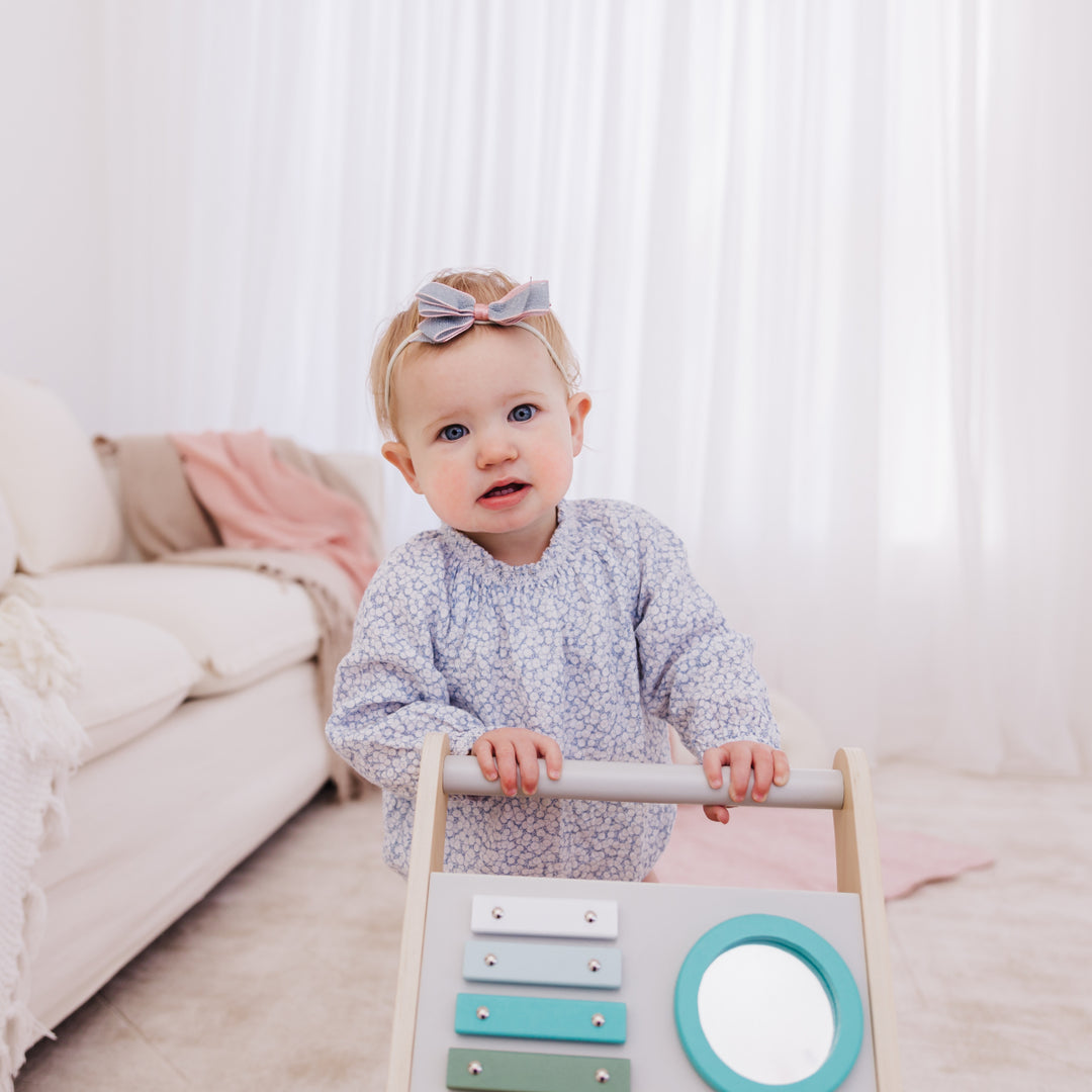 Baby playing with a wooden toy in a cozy living room.