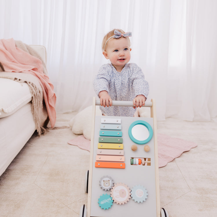 Baby playing with a colorful educational toy in a bright room.
