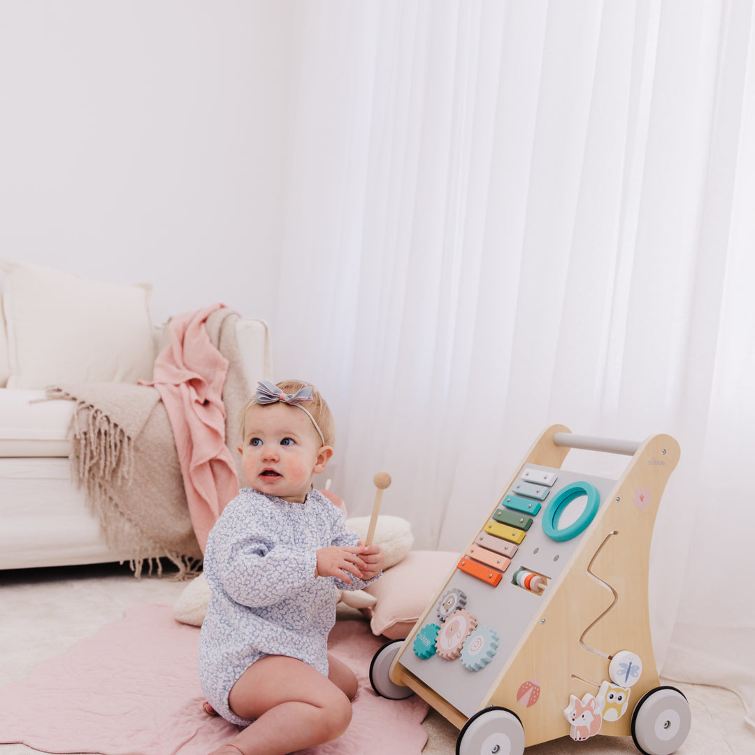 Baby playing with a wooden toy in a cozy living room.