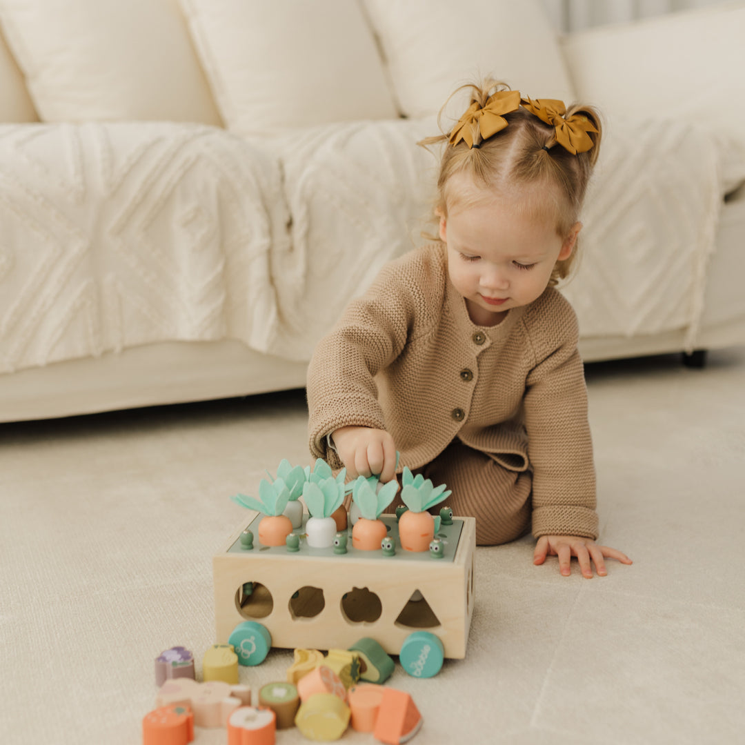 Child playing with a wooden toy on a light-colored floor.
