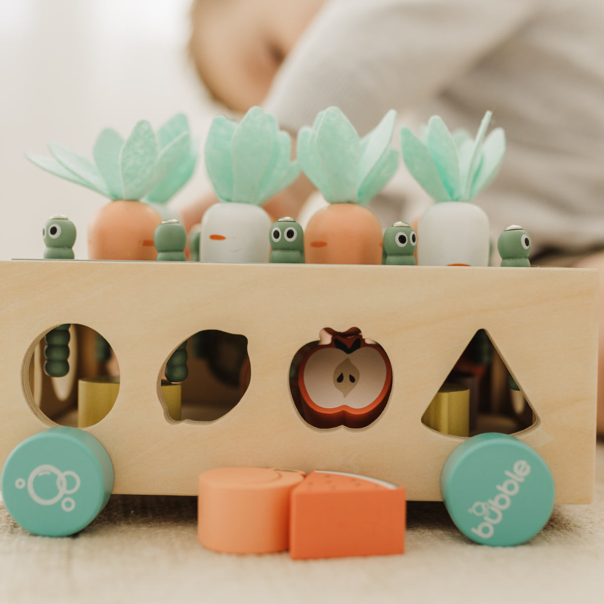 Wooden shape sorter toy with colorful shapes and a blurred background