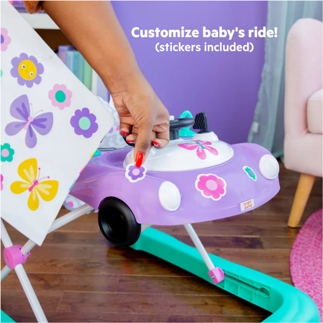 Purple baby walker with butterfly and flower designs, held by a hand.