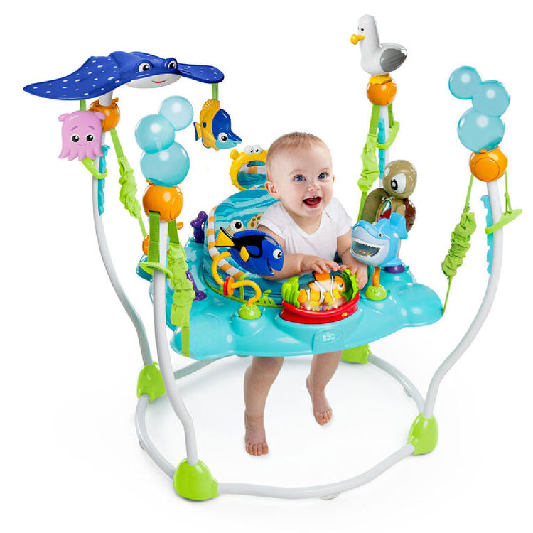 Baby in a colorful activity center with various toys on a white background