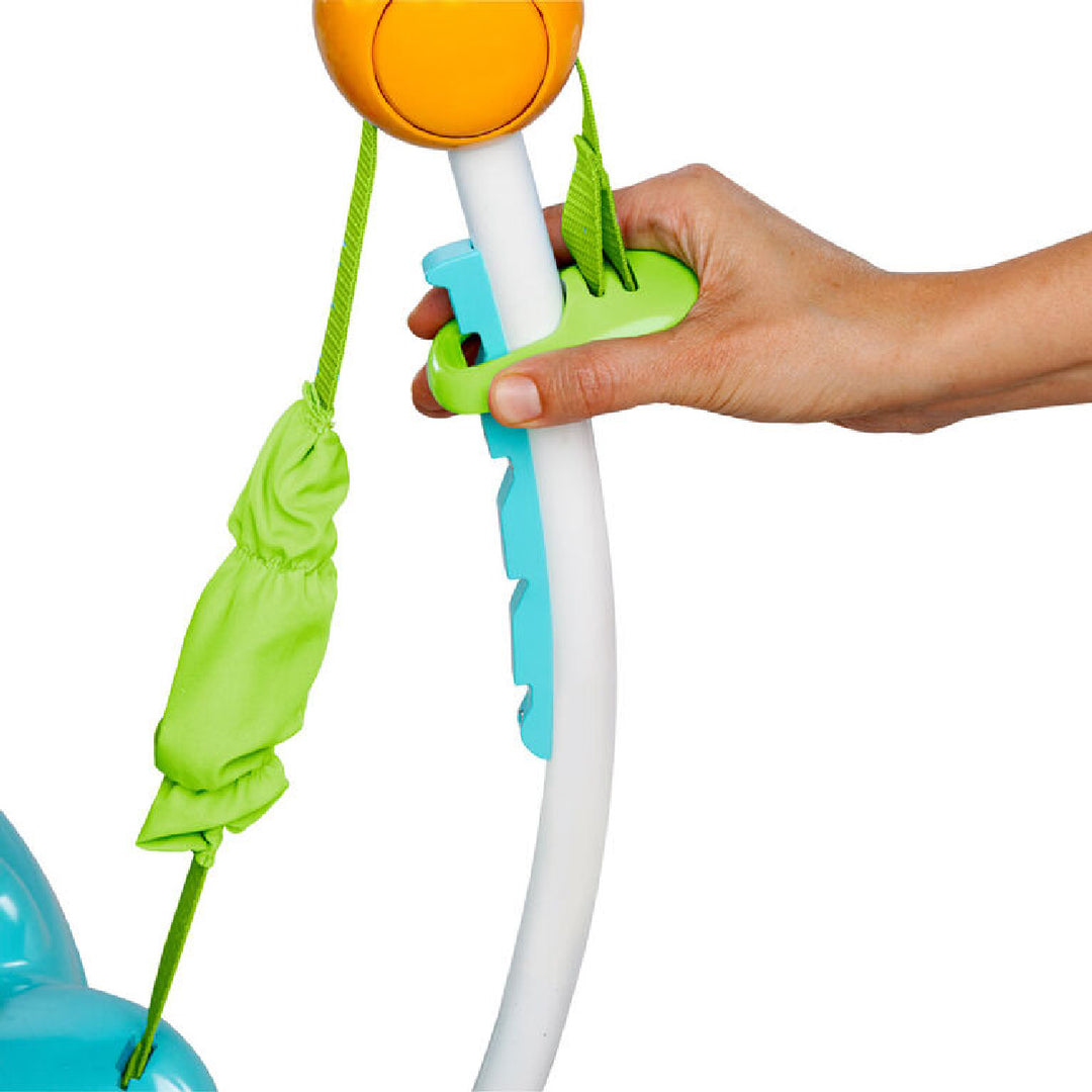 Hand holding a colorful toy with green bag and orange top on a white background