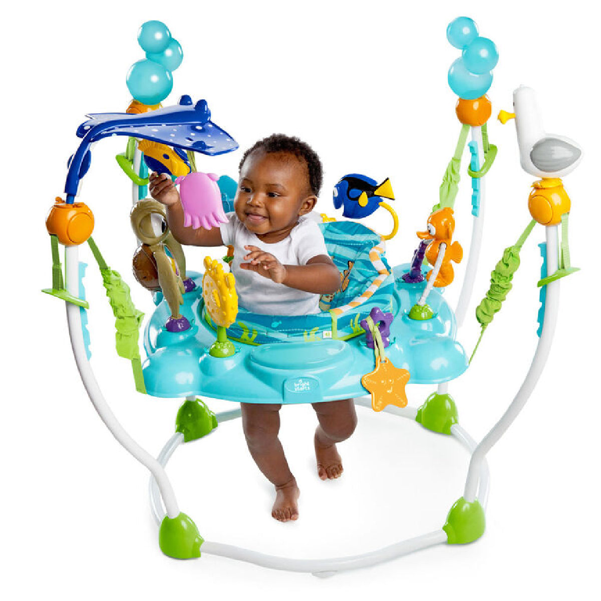 Baby playing in a colorful baby jumper with various toys on a white background
