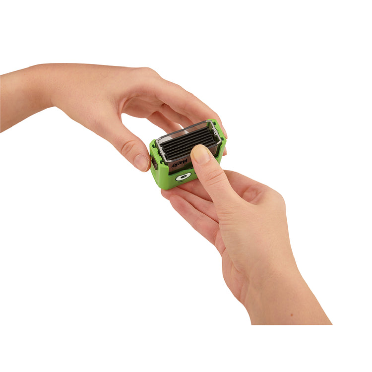 Hand holding a green and black small device on a white background