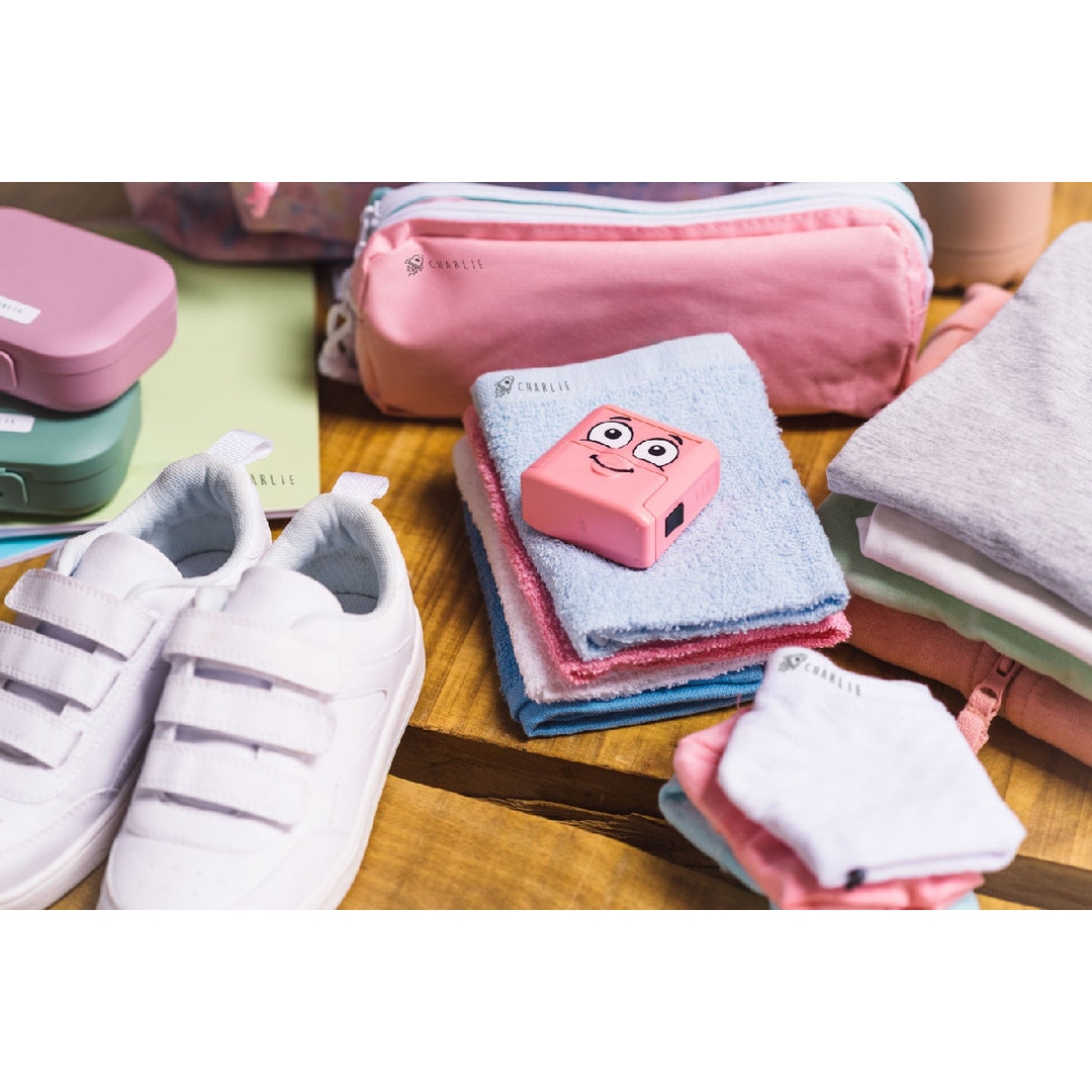Pink cartoon character on a folded towel with white sneakers and colorful containers in the background.