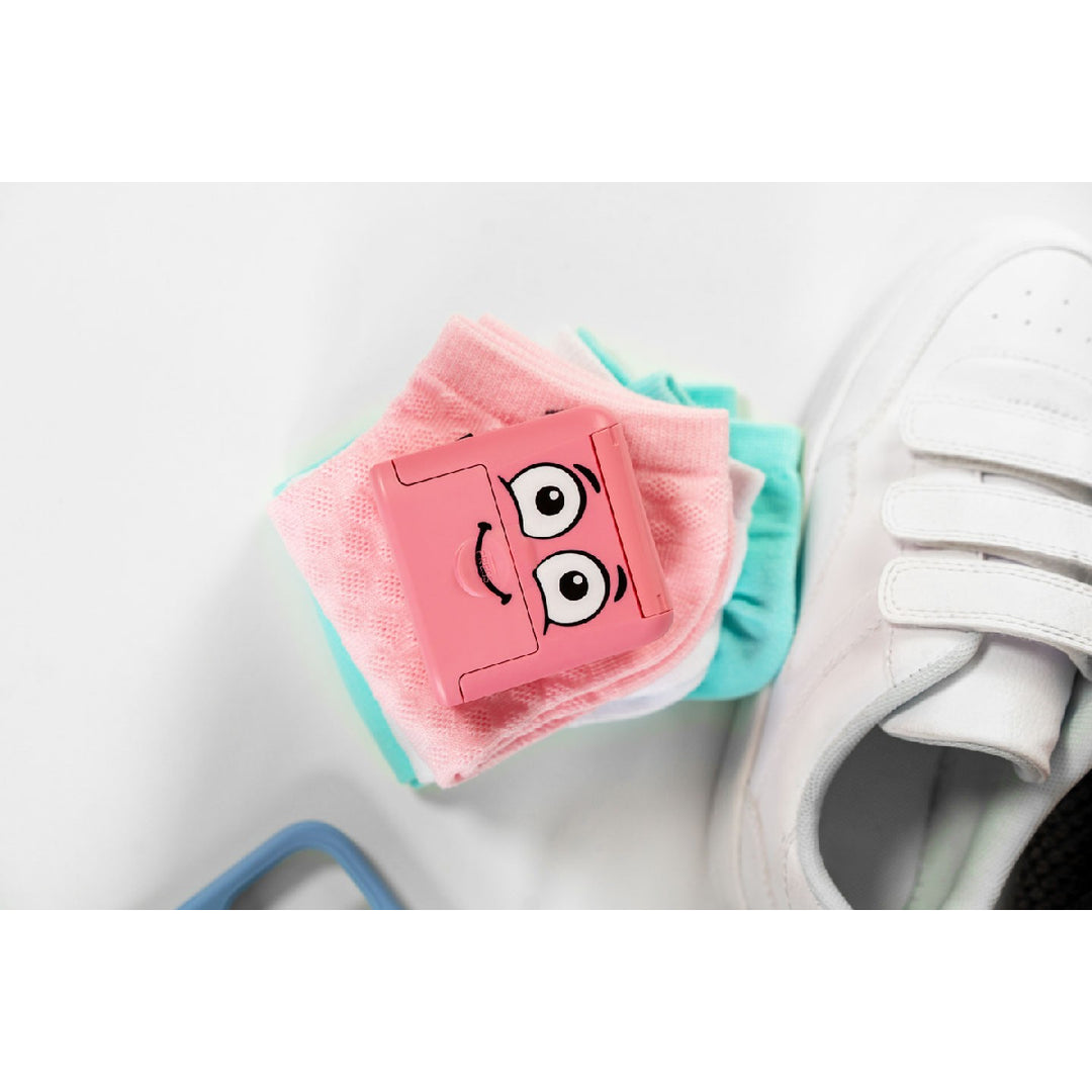 Pink cartoonish shoe polish with a white shoe in the background