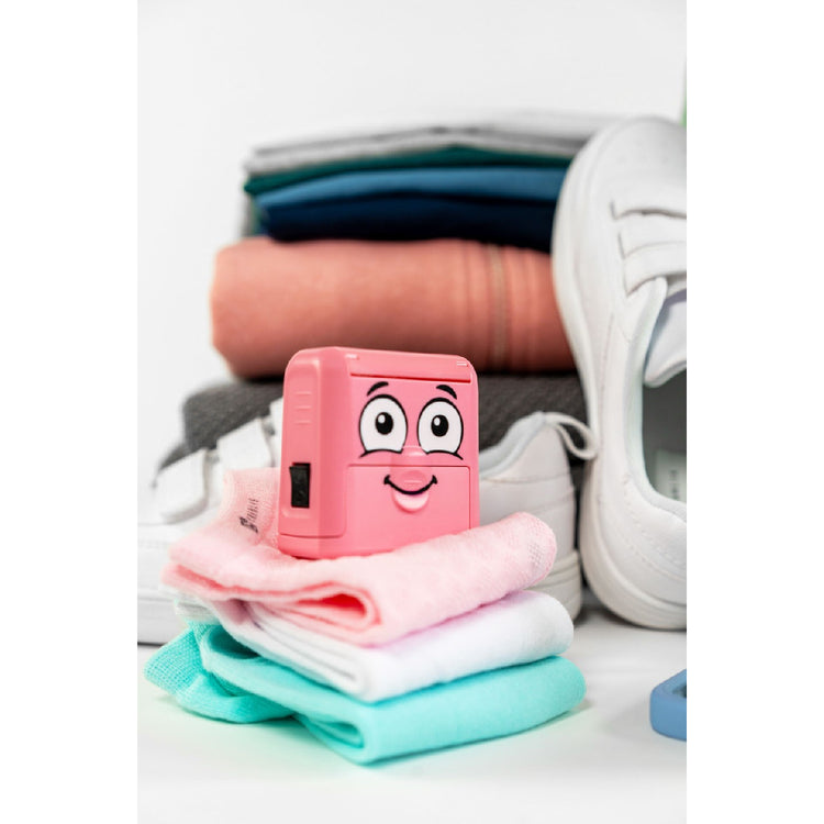 Pink cartoon-style device on folded clothes with a white background