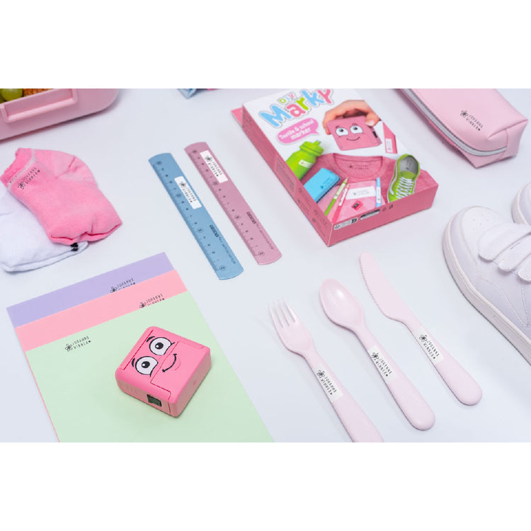 Children's tableware set with pink cutlery, gloves, and a ruler on a white background