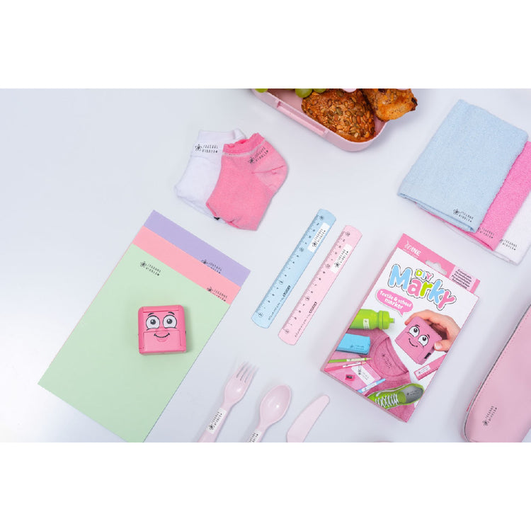 Collection of stationery items including notebooks, a ruler, and a pink pouch on a white surface.