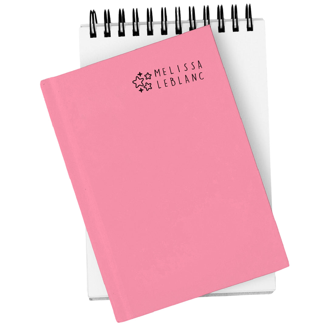 Pink notebook with 'Melissa LeBlanc' branding on a white background