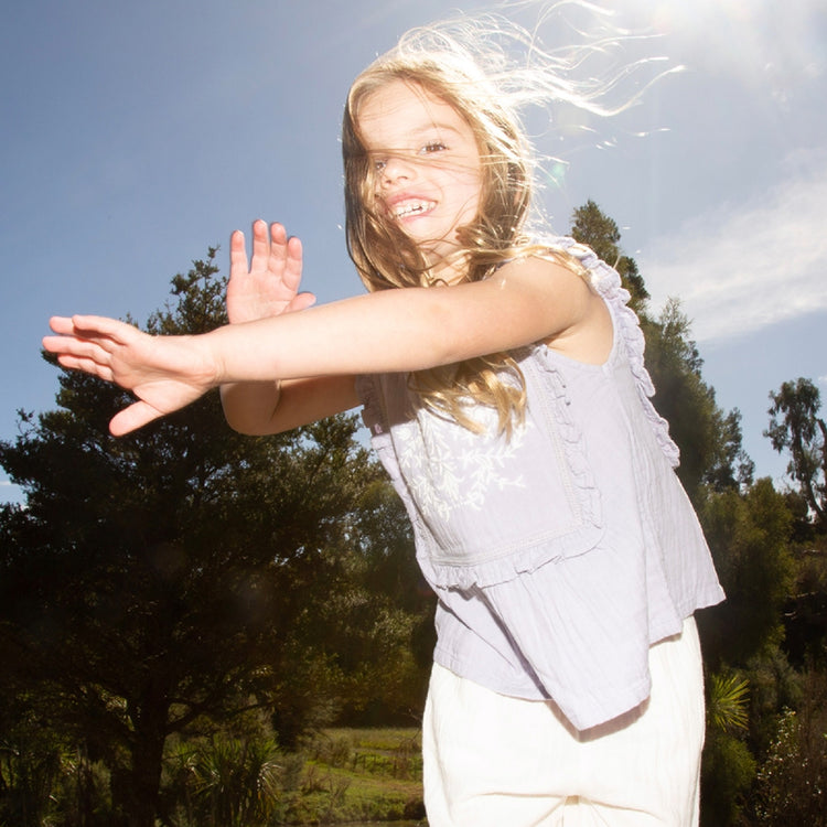 Young girl with arms outstretched in a natural setting