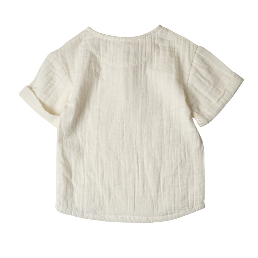 Back view of a textured beige shirt on a white background