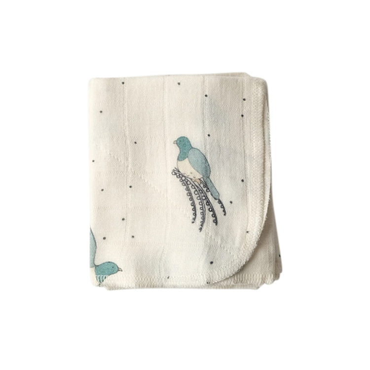 Folded blanket with bird patterns on a white background
