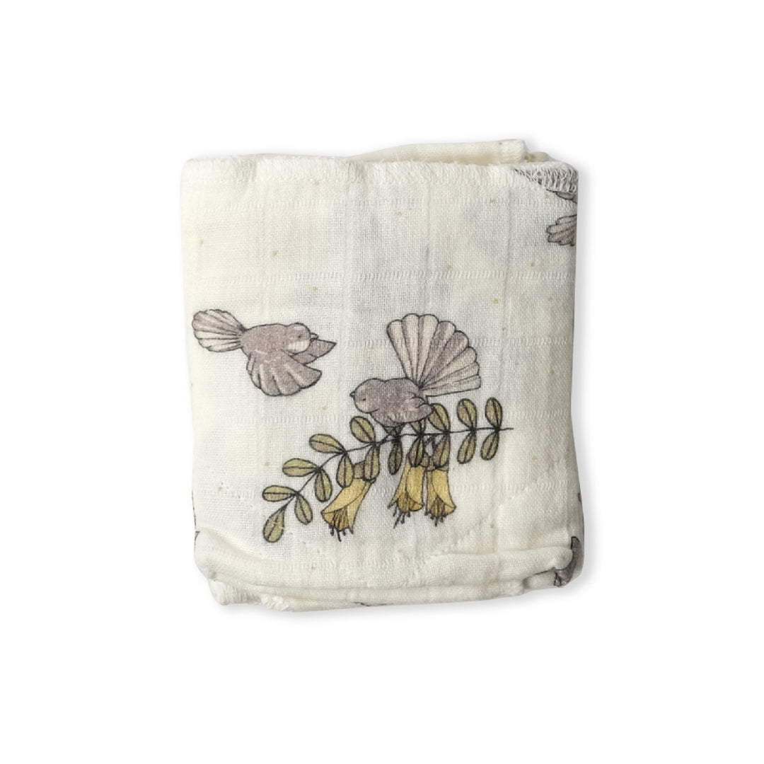 Fabric swaddle with bird and leaf pattern on a white background