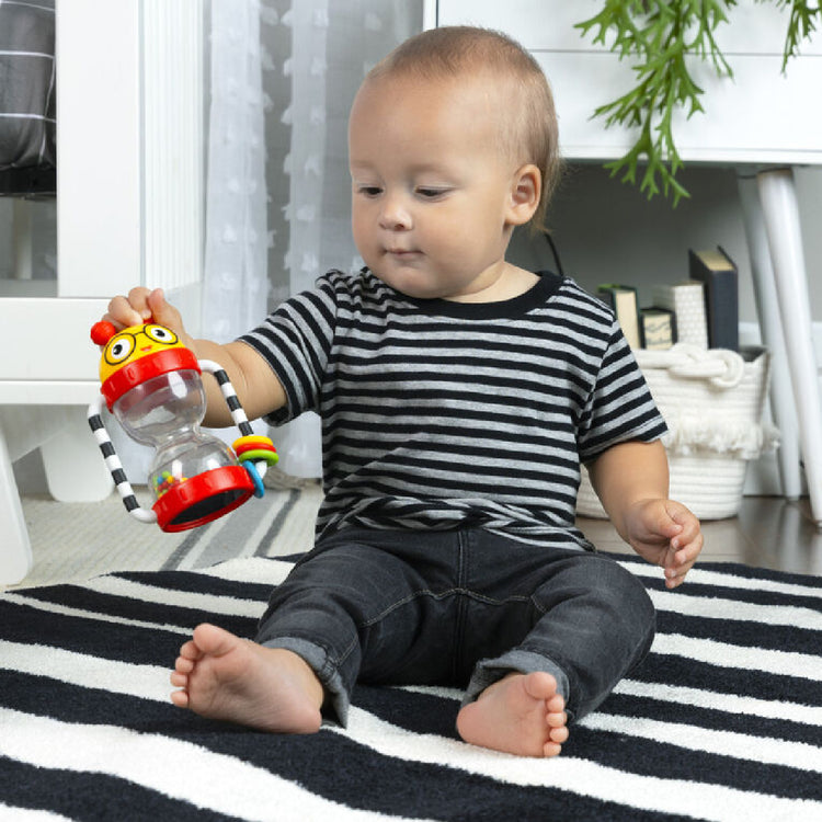 Child playing with a colorful toy on a black and white striped rug