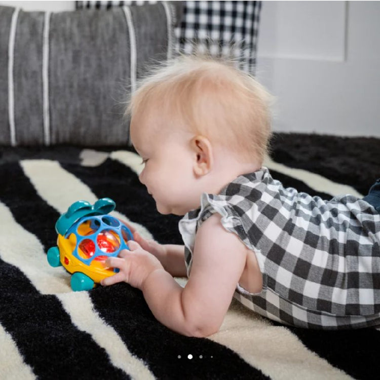 Baby playing with a colorful toy on a striped rug