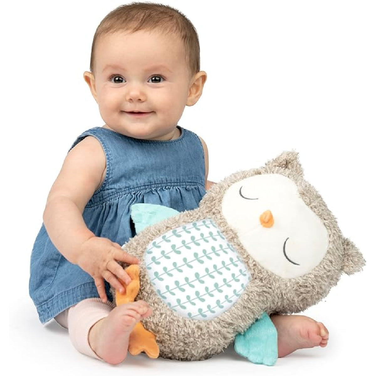Baby holding a plush owl toy against a white background