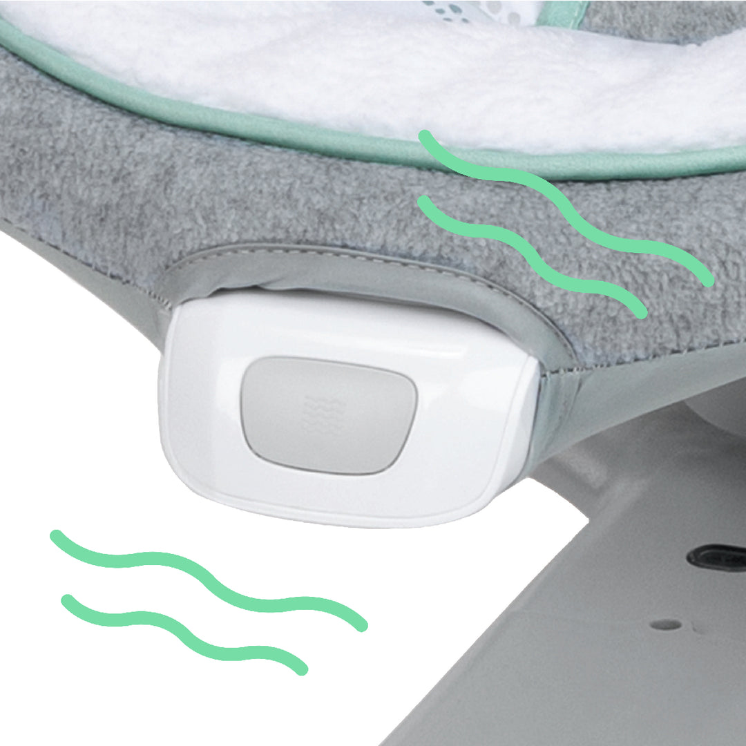 Close-up of a baby bouncer with a control panel and green wavy lines on a white background