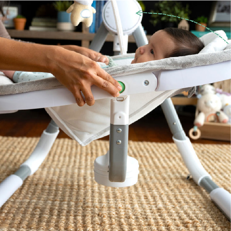 Baby in a white crib with a textured rug below