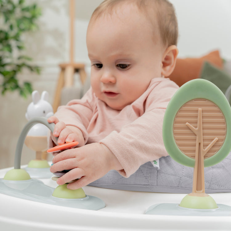 Baby playing with a wooden toy set on a white surface
