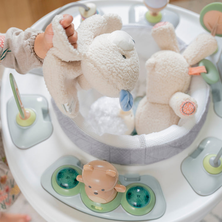 Baby toy with plush animals in a circular tray, likely in a baby walker.