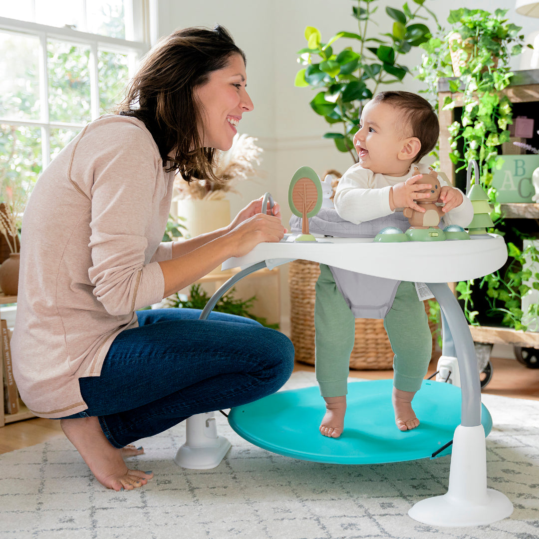 Woman and baby using a baby walker in a home setting