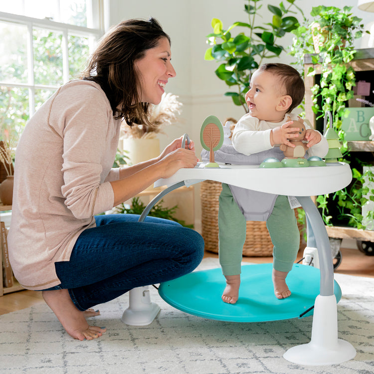 Woman and baby using a baby walker in a home setting