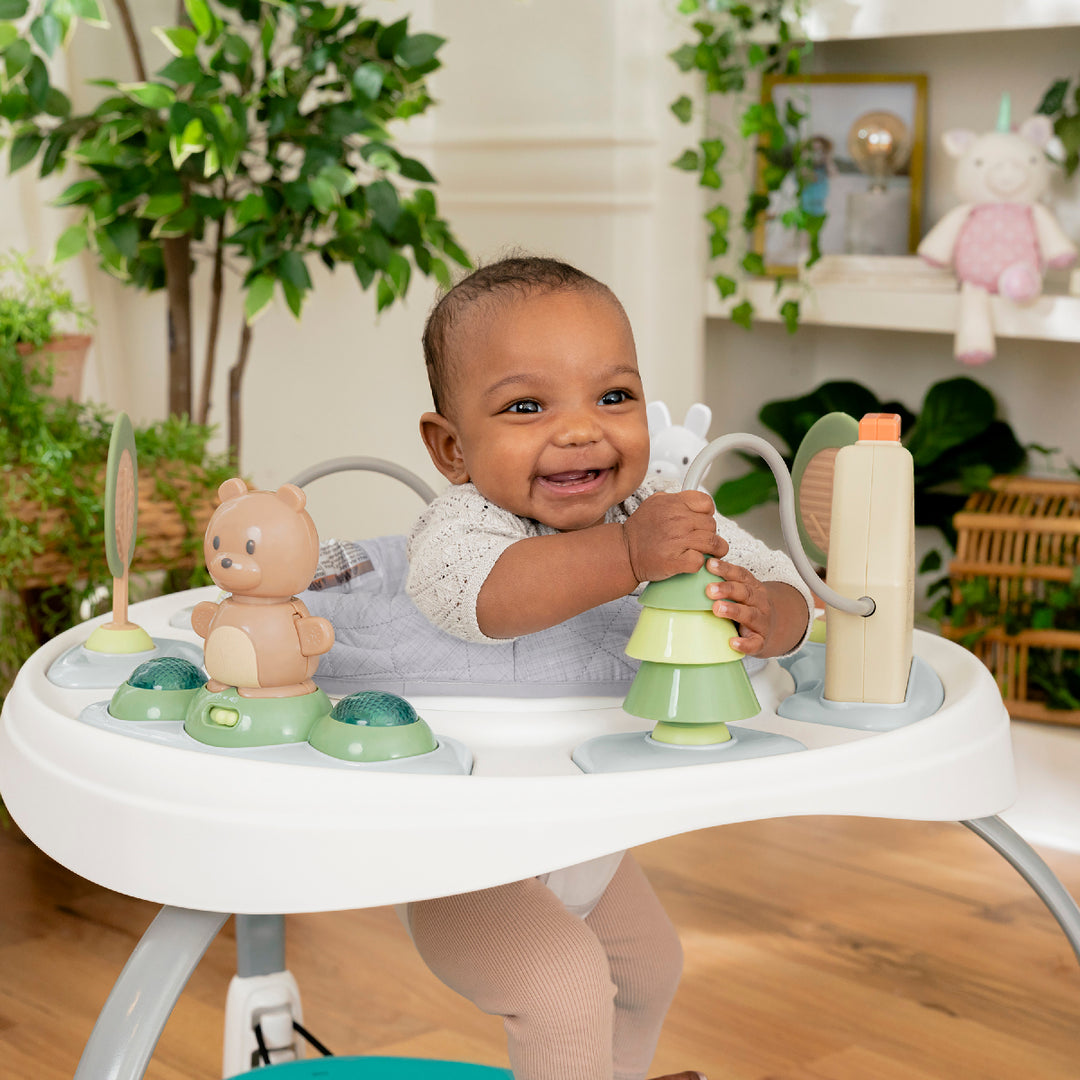 Baby playing with toys in a high chair in a home setting