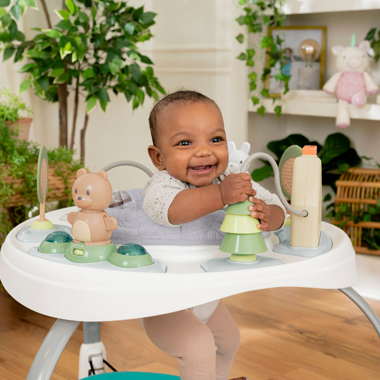Baby playing with toys in a high chair in a home setting