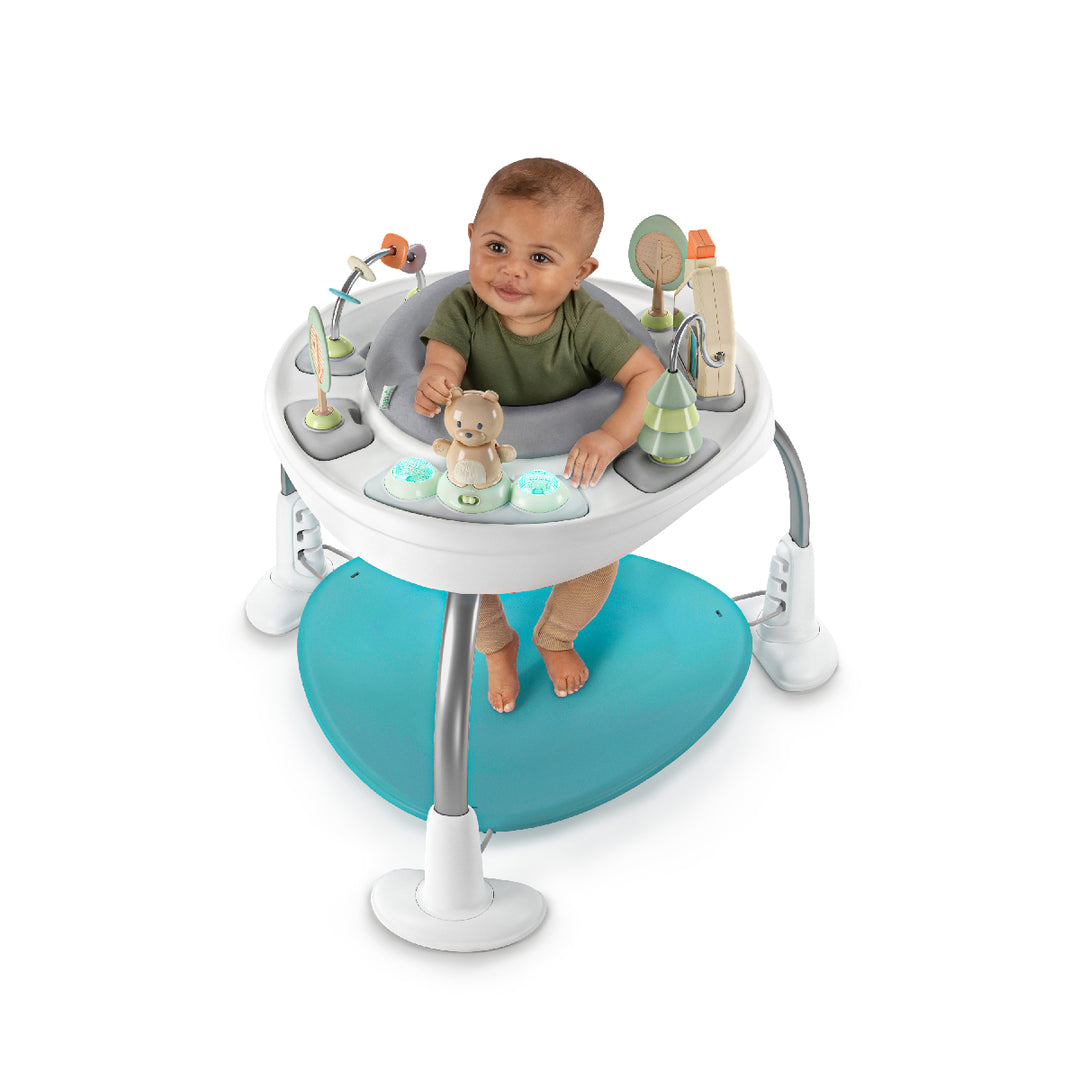 Baby in a activity center with toys on a white background