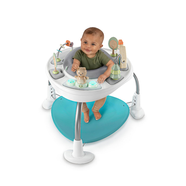 Baby in a activity center with toys on a white background