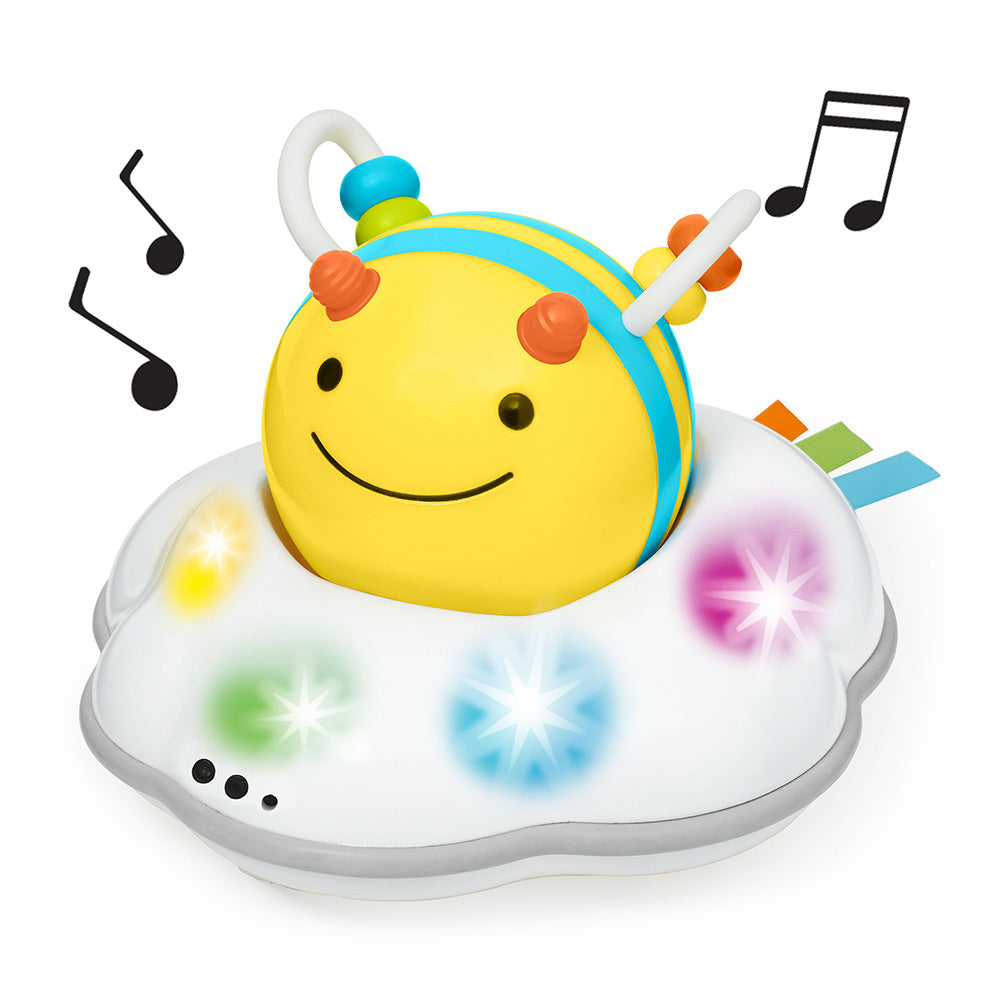 Colorful toy bee with lights and music notes on a white background