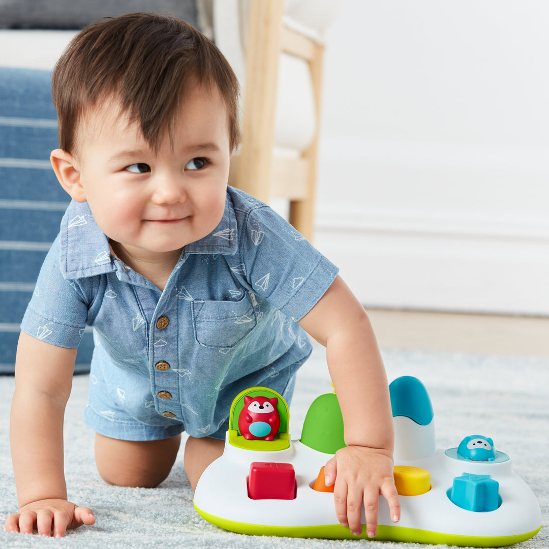 Child playing with a colorful toy on a carpeted floor