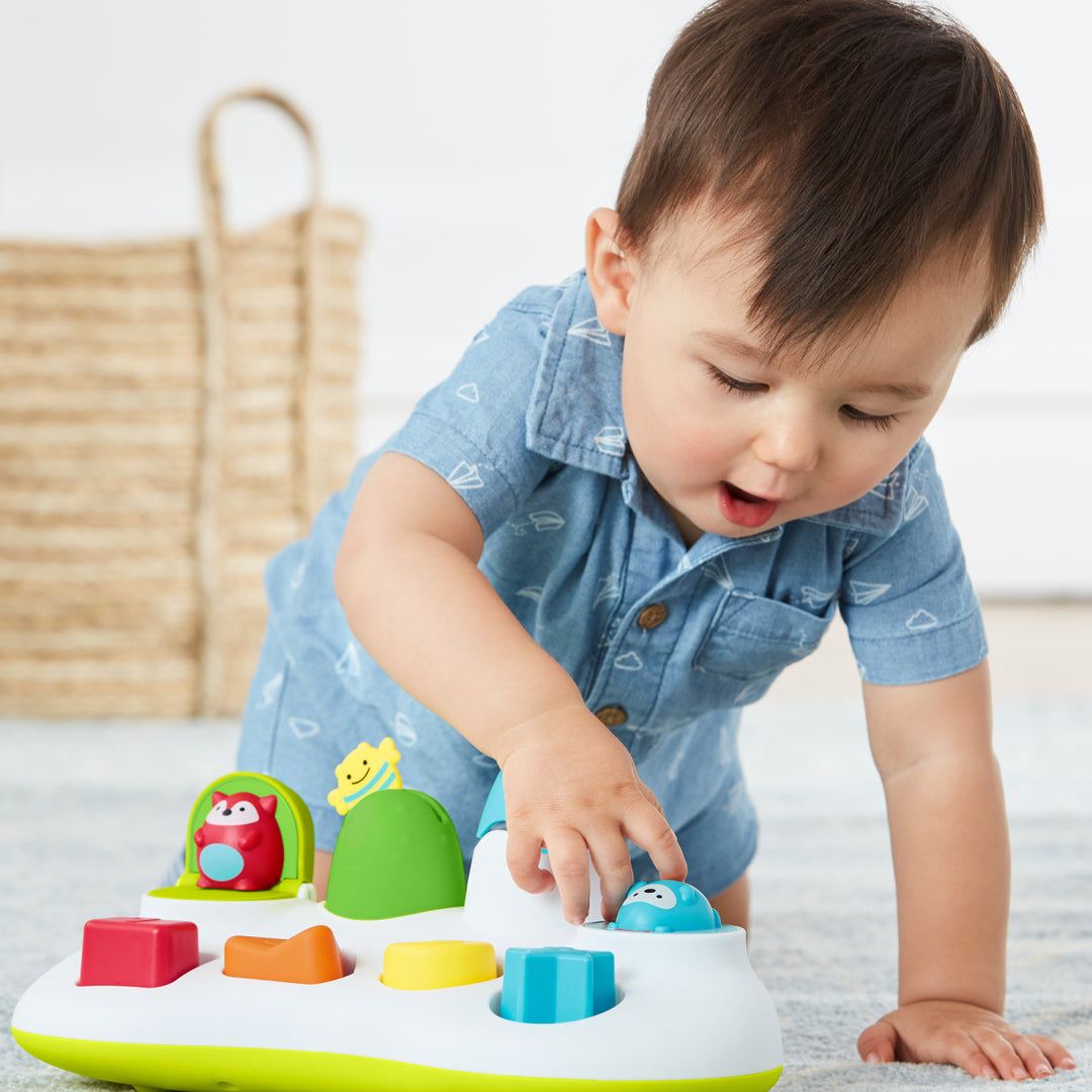 Child playing with a colorful toy on a light surface