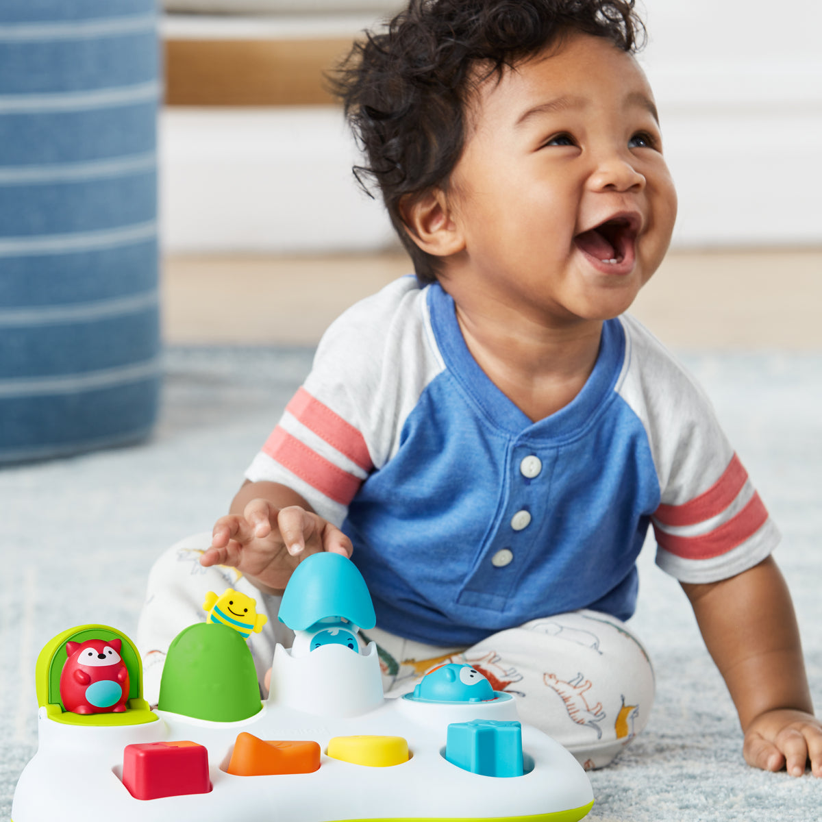 Child playing with a colorful toy on a light-colored floor.