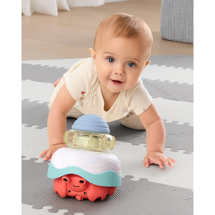 Baby playing with a colorful toy on a soft play mat