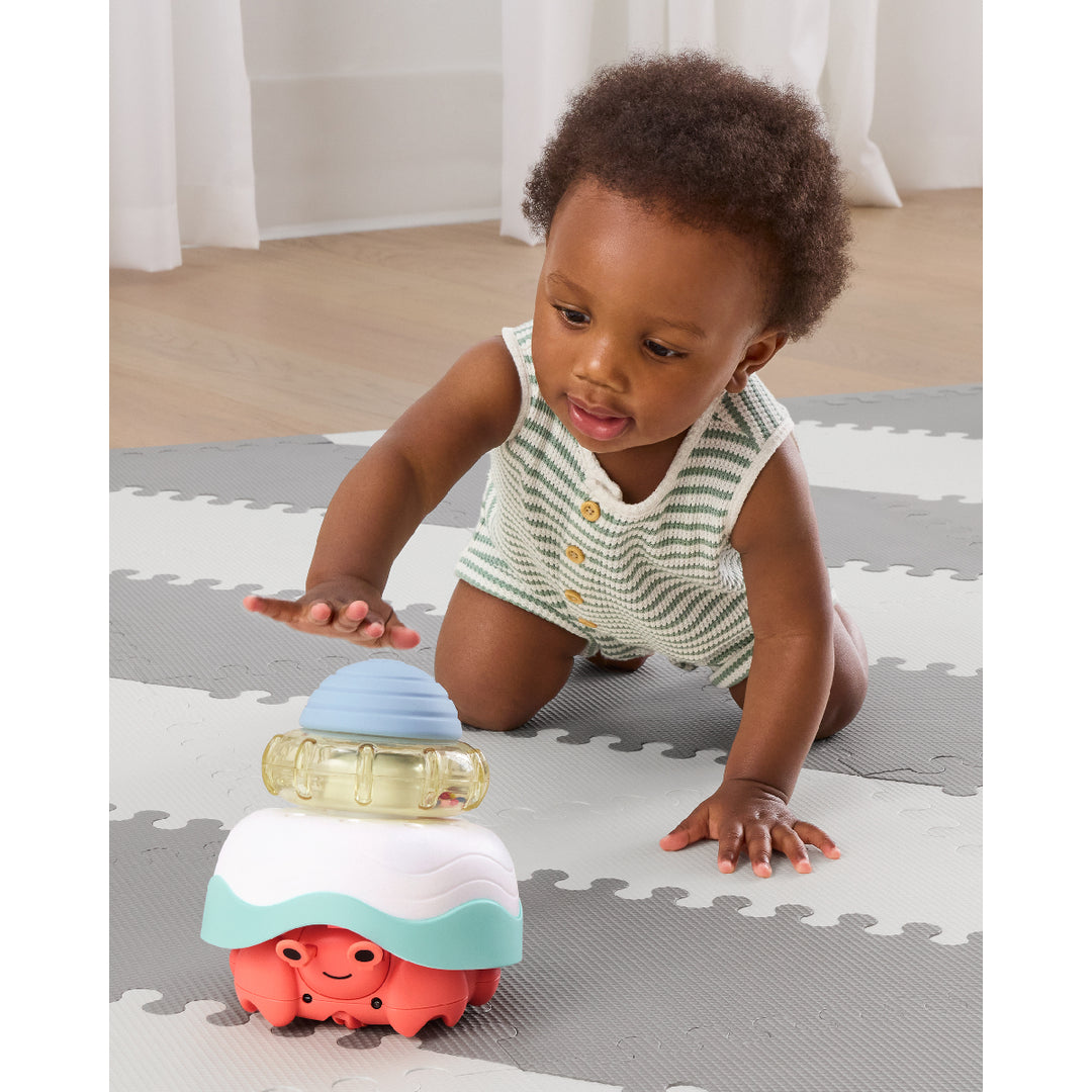Child playing with a colorful toy on a foam play mat