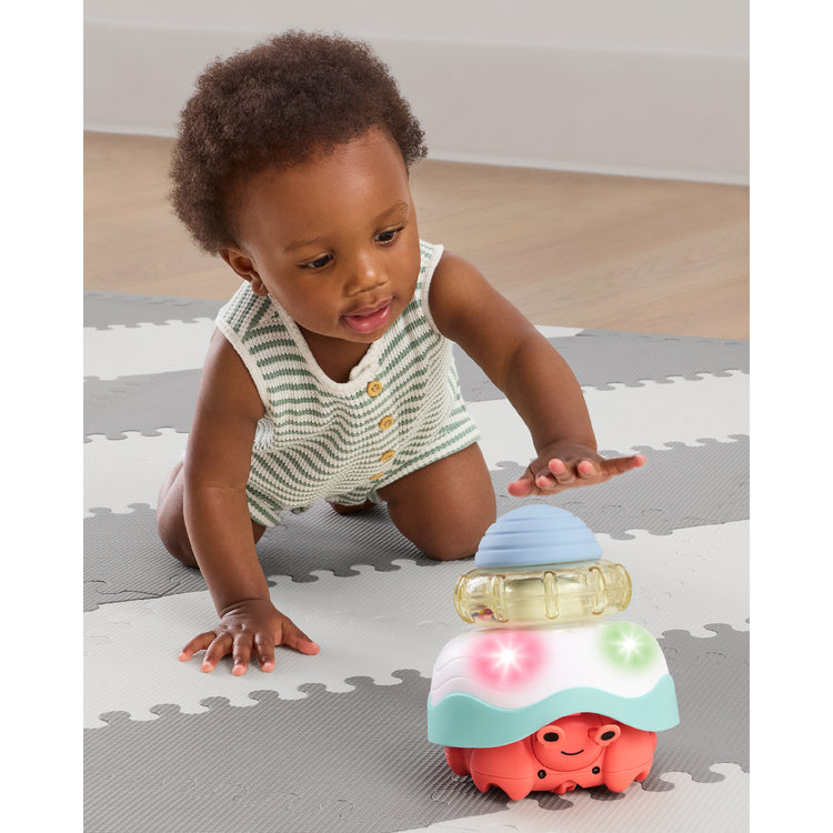 Child playing with a colorful toy on a play mat