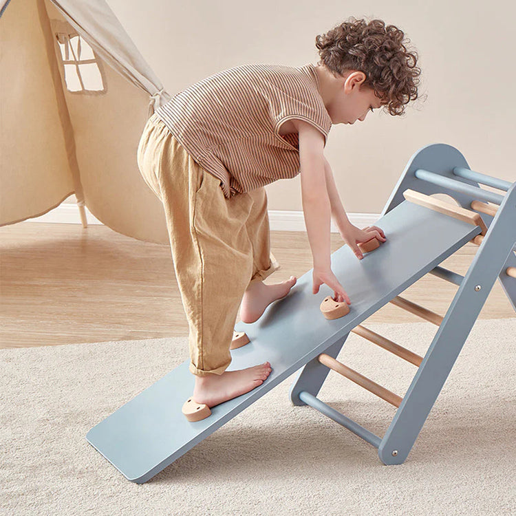 Child playing on a small blue slide indoors